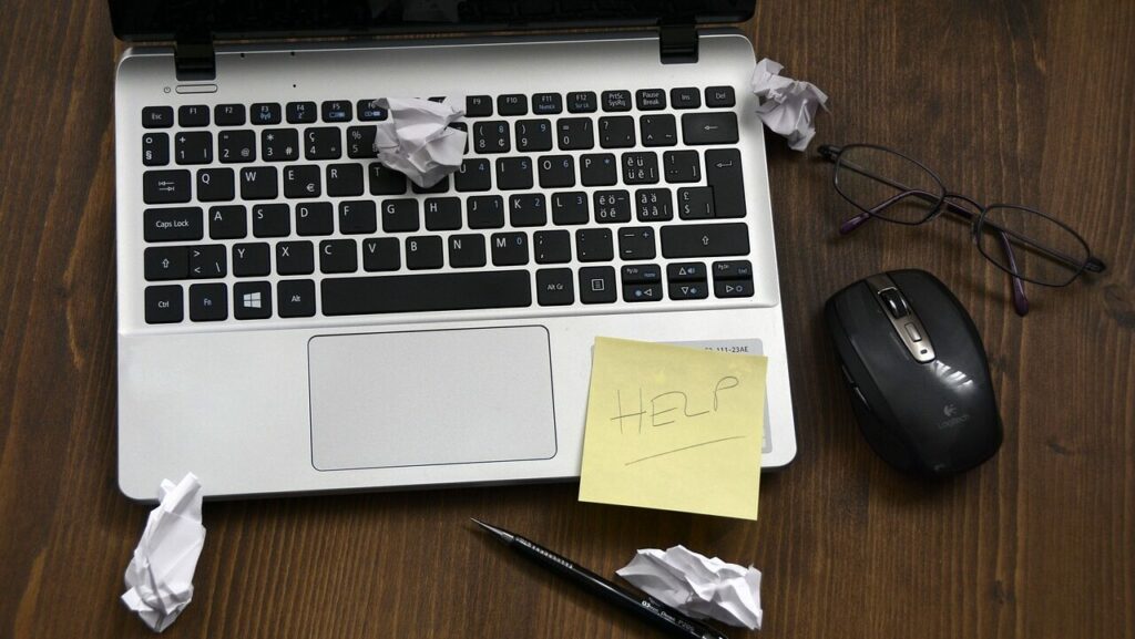 Laptop with help sign and garbage around. Need home computer support.